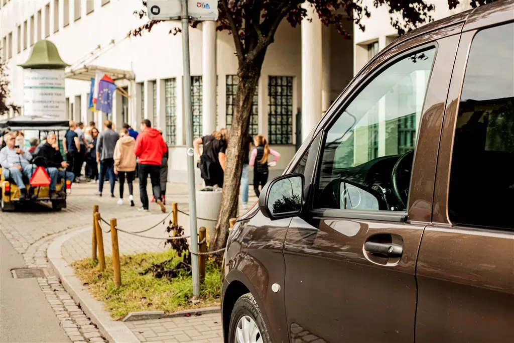 A large group of tourists leaving their premium Krakow Direct tour cars to enter the Schindler's Factory Museum