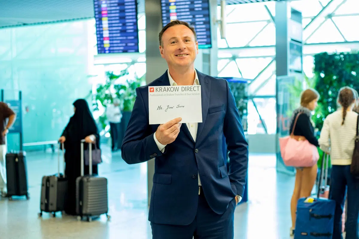 Driver holding a name sign at arrivals in Krakow Airport